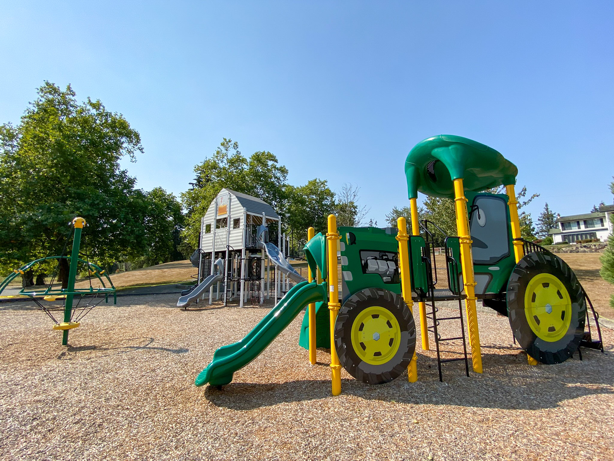 The tractor-themed playground at Kelsey Creek Farm in Bellevue features a bright red play tractor that kids and toddlers love to climb and explore. Surrounded by open green space and farm animal enclosures, this unique playground is a family favorite and offers a perfect mix of farm charm and fun outdoor play. It’s a great spot for little ones to use their imagination while enjoying fresh air and nature.