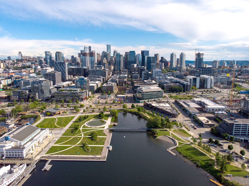 Lake Union Park with the South Lake Union neighborhood in the background, home to Amazon’s global headquarters and major Google offices, showcasing Seattle’s transformation into a vibrant, walkable tech hub with green spaces and waterfront access.