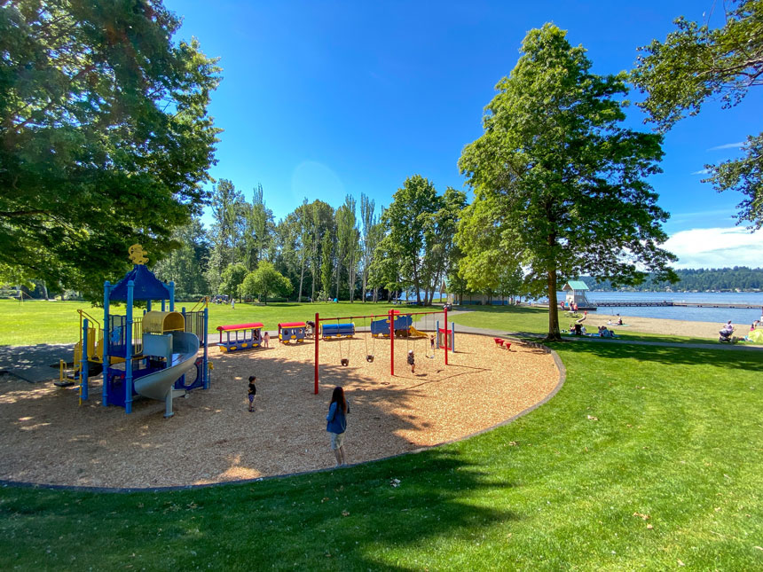 The playground at Newcastle Beach Park in Bellevue, Washington, features a variety of kid-friendly equipment including slides, climbing structures, and swings, all set within a shaded, wooded area near Lake Washington. With its sandy beach, picnic areas, and nearby swimming access, this park is a favorite Eastside destination for families looking to combine playtime with waterfront fun.