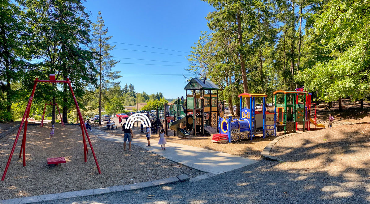 Wilburton Hill Park playground in Bellevue featuring a large play structure with a thrilling zip line, slides, climbing nets, and open spaces—ideal for adventurous kids and active family outings.