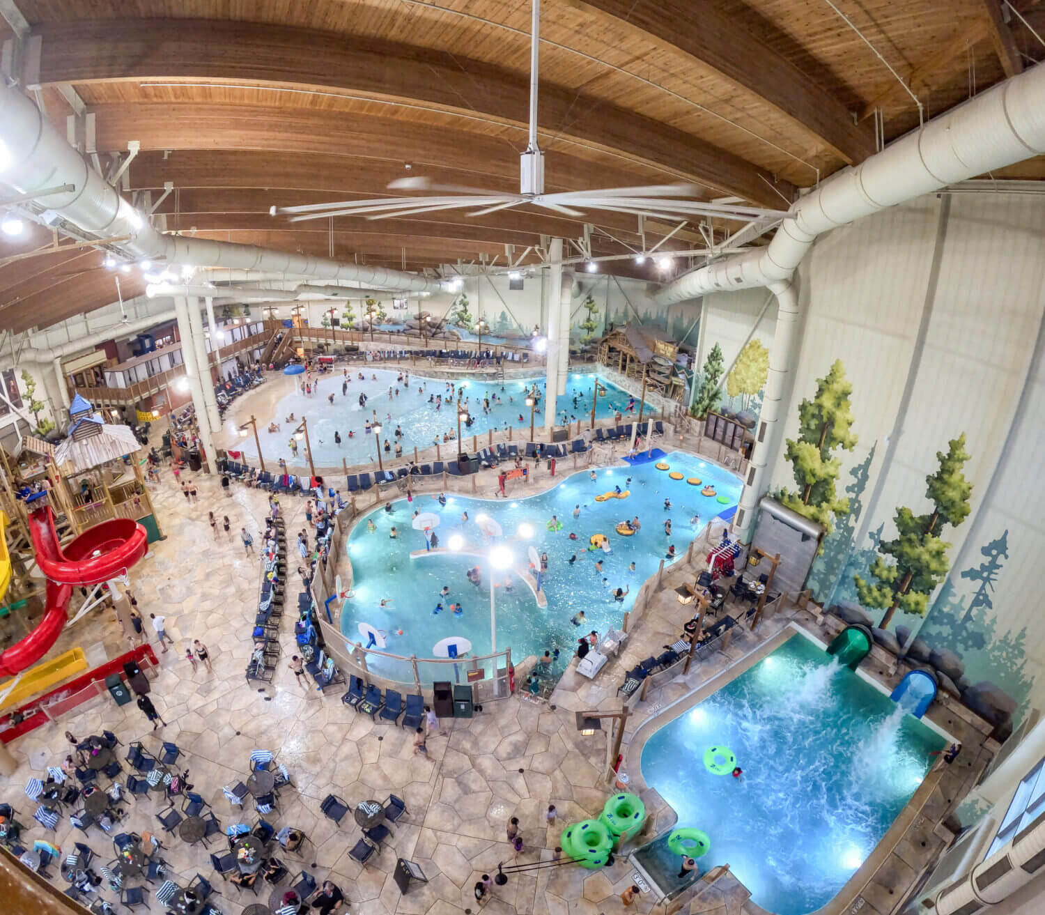 Great Wolf Lodge photo from above showing the wave pool, basketball hoop pool, inner tube slide and plenty of chairs and tables for guest