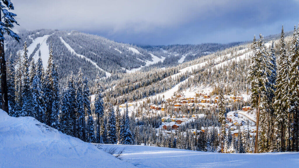 Just six hours from Seattle, Sun Peaks is a hidden gem nestled in British Columbia’s Thompson-Okanagan region, offering a scenic alpine escape that feels worlds away without the need for air travel. In this winter landscape, snow-covered trees blanket the surrounding hills, framing the high alpine village and its peaceful ski slopes. This breathtaking view captures what makes Sun Peaks so special for Seattle families—stunning natural beauty, a laid-back atmosphere, and crowd-free skiing. The resort’s family-friendly vibe, wide open runs, and charming pedestrian village make it a perfect winter road trip destination for skiing, snow play, and cozy mountain memories.