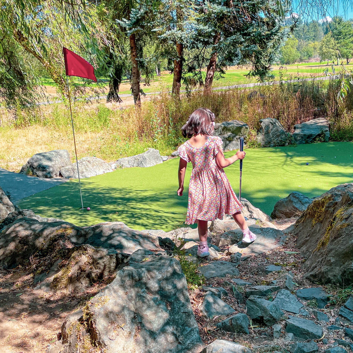 Toddler girl playing mini golf in Redmond WA at Willows Run