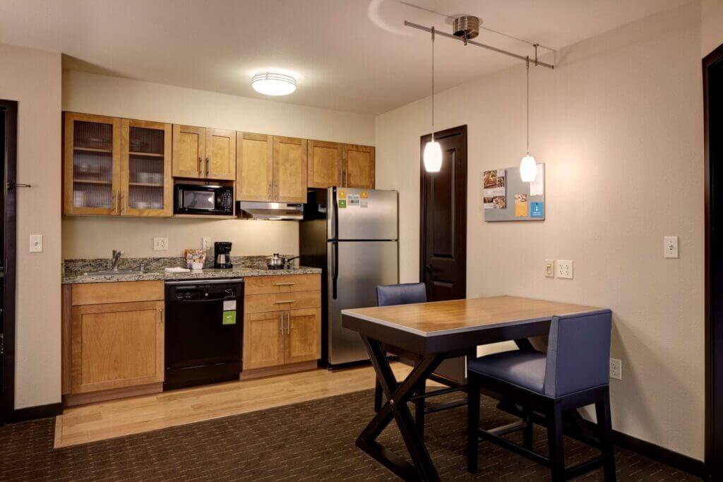 Kitchenette and small dining table in a suite-style room at Hyatt House Bellevue, offering families the convenience of cooking simple meals and enjoying them together—perfect for longer stays with kids.