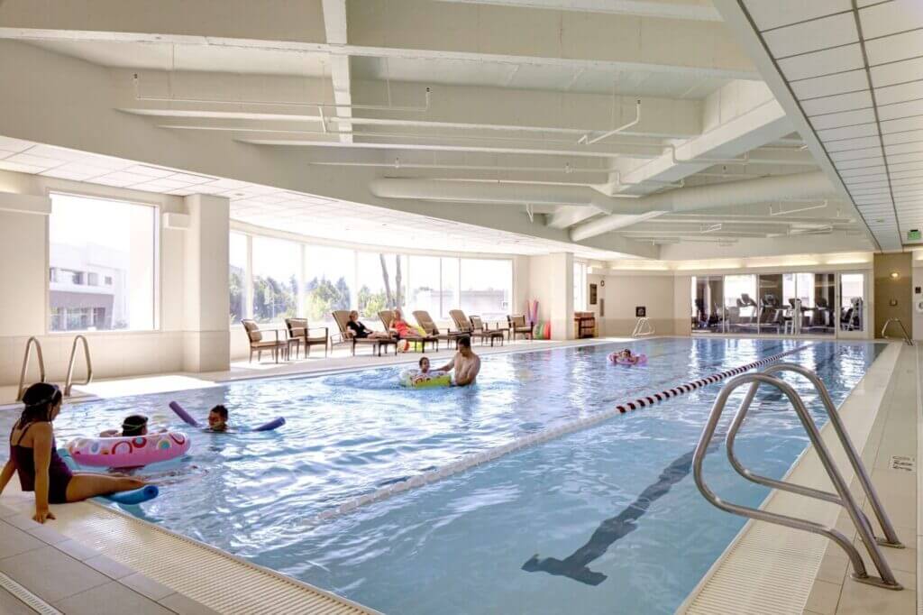 Hyatt Regency Bellevue indoor pool, featuring a clean and spacious design perfect for families with kids. The pool area offers plenty of natural light and lounge seating, making it an ideal spot to relax after a day exploring downtown Bellevue.