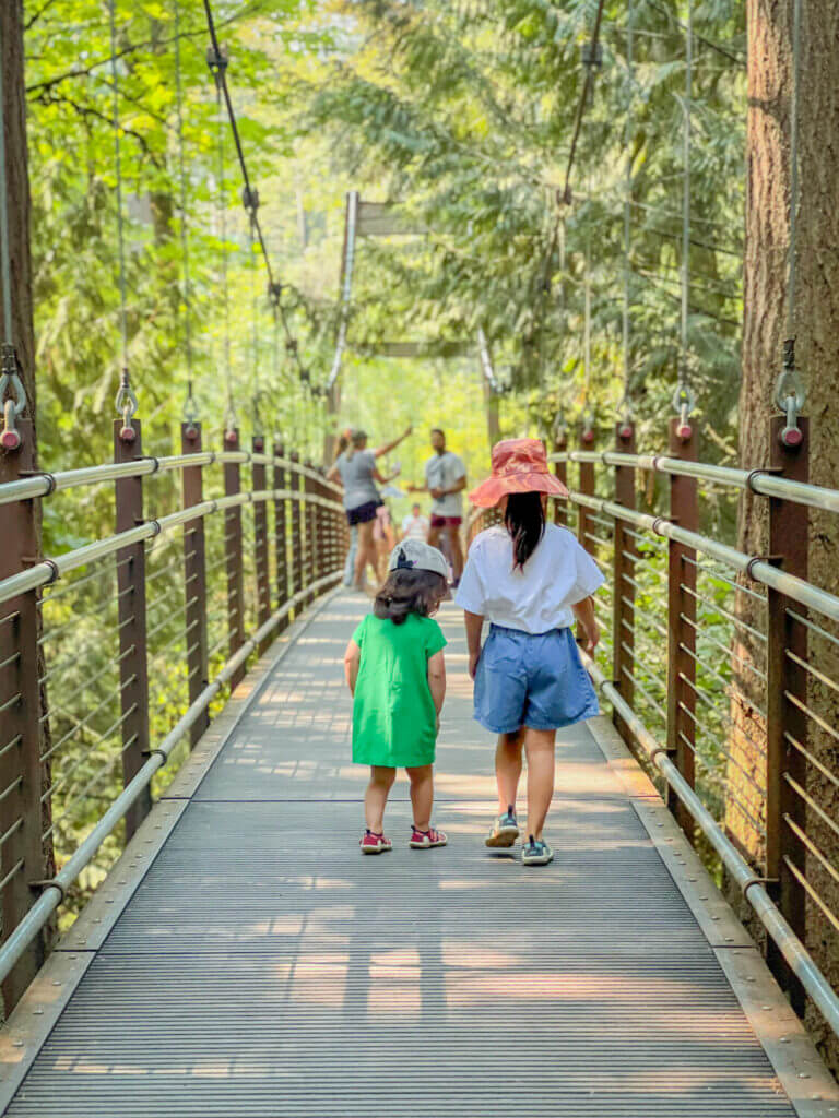 Two girls walking across the Bellevue Botanical Garden Suspension Bridge