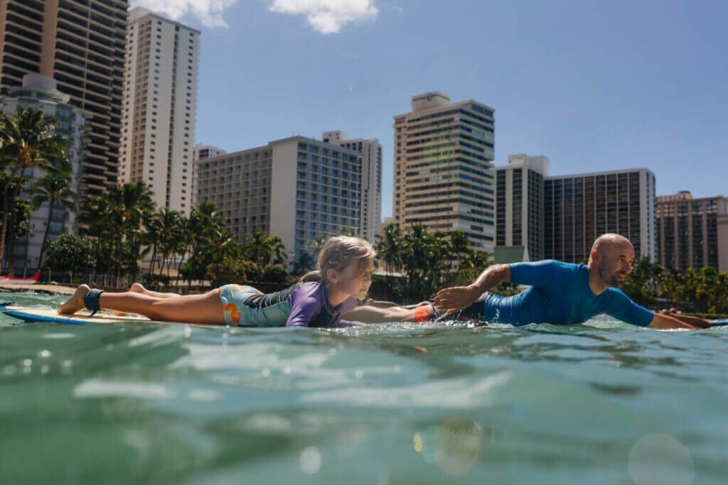 Dad teaching his determined daughter to surf in Waikiki, Hawaii on Oahu.