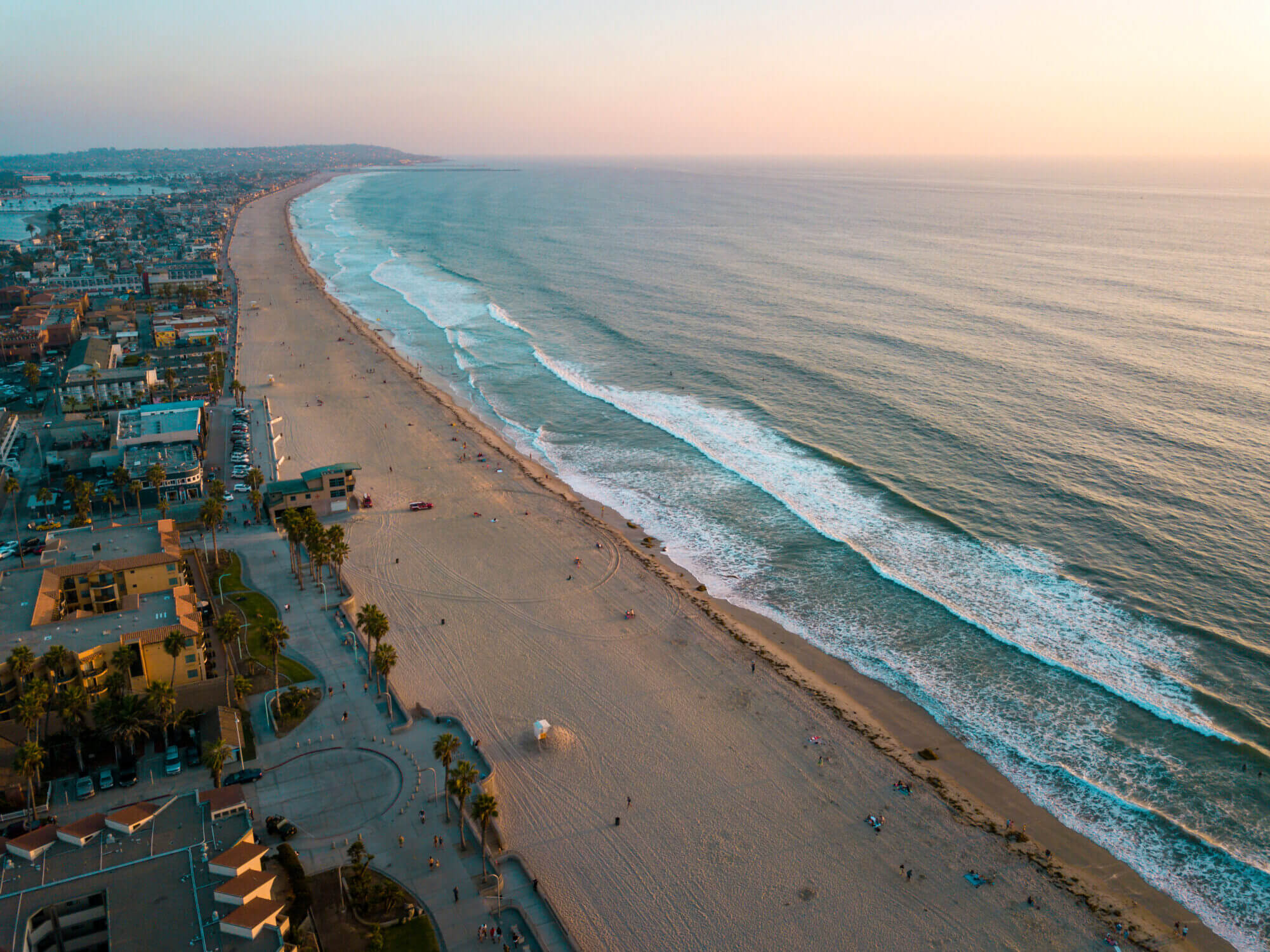 Aerial view of Pacific Beach and the surrounding Mission Bay in San Diego, California, a perfect destination for a kid-friendly family vacation. Pacific Beach offers a lively boardwalk, soft sandy shores, and gentle waves ideal for kids to splash and play.