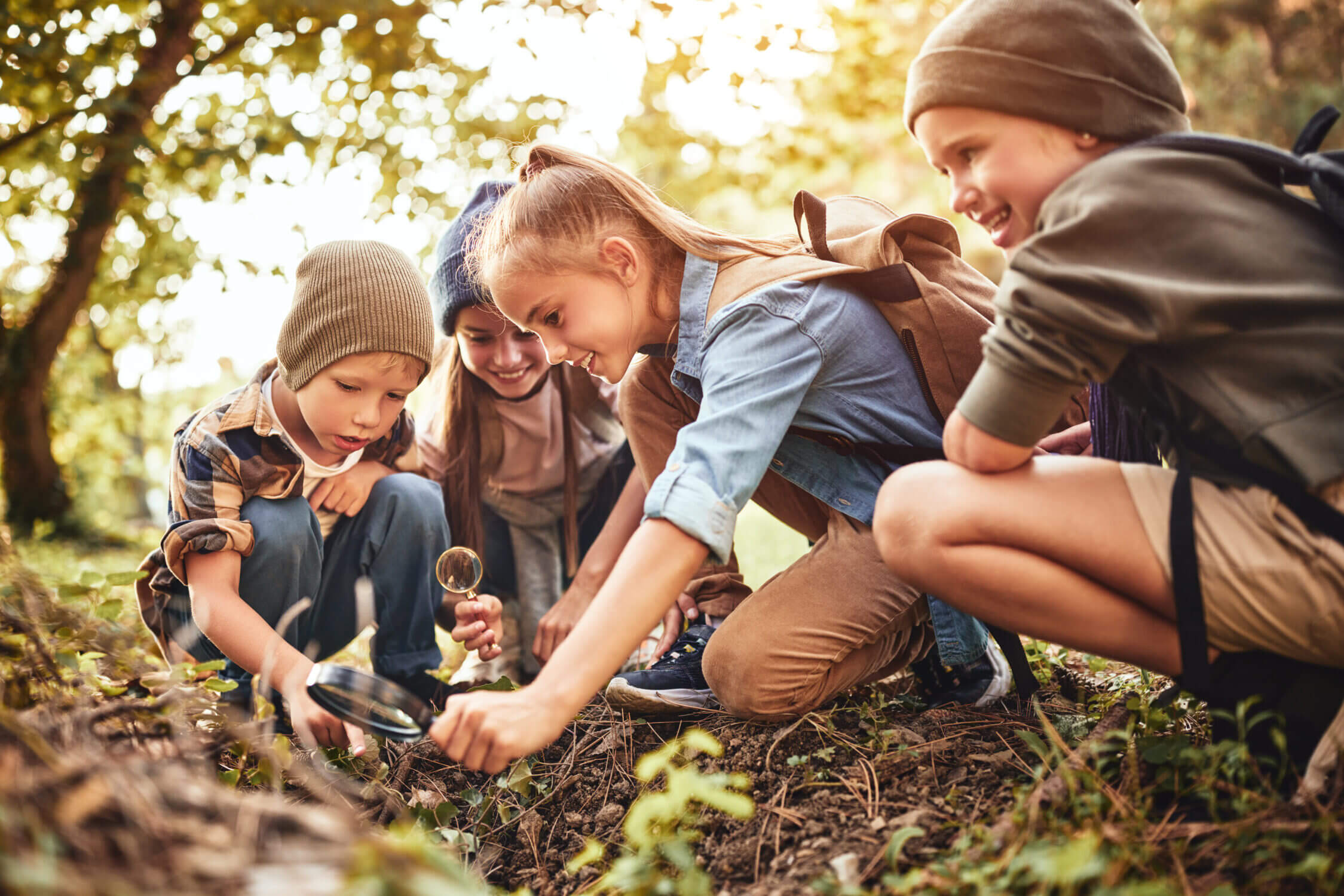Kids outdoors using a magnifying glass to closely examine the bark of a tree—an engaging and curious moment that perfectly captures the spirit of outdoor adventure summer camps. Featured in our blog roundup of the best summer camps for kids near Seattle, Bellevue, and the Eastside, camps like Avid4 Adventure and Trackers Earth offer hands-on, nature-based learning experiences. These camps go beyond typical recreation, introducing children to hiking, survival skills, wildlife tracking, nature journaling, and environmental awareness. With experienced guides and stunning Pacific Northwest settings, outdoor adventure camps are a fantastic way for kids to unplug, build confidence, and connect with nature.