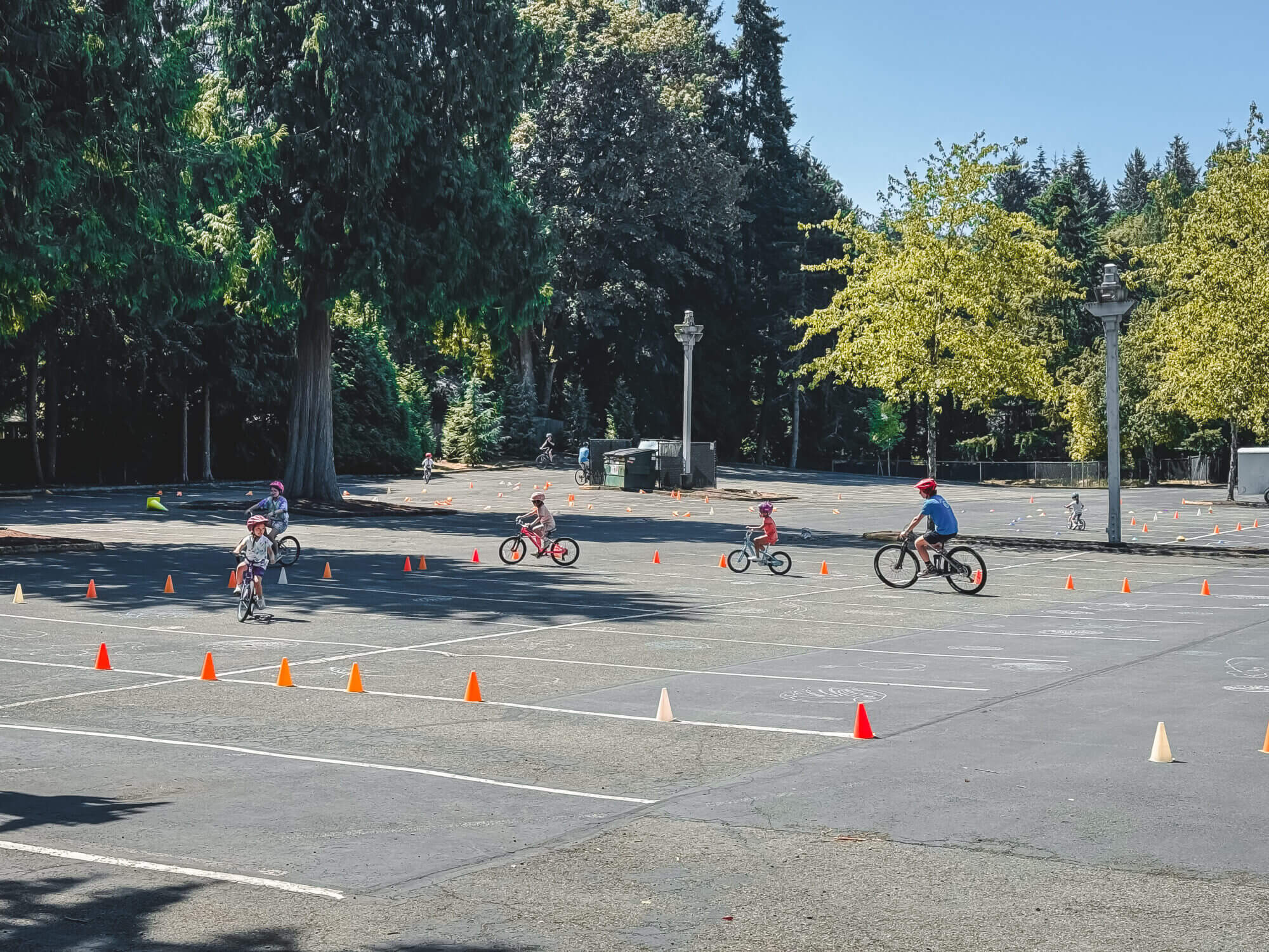 Outdoor summer camps for kids in the greater Seattle area and Eastside—such as Bellevue, Redmond, and Kirkland—offer fantastic opportunities for active play, skill-building, and fun in the sun. Pictured here is a bike camp set up in a safe, coned-off parking lot where kids ride through obstacle courses and practice balance, steering, and road awareness. Programs like Pedalheads and other local camps focus on outdoor learning through biking, hiking, nature exploration, and sports. These camps give children the chance to build confidence, enjoy fresh air, and stay active all summer long—perfect for families looking for engaging outdoor experiences close to home.