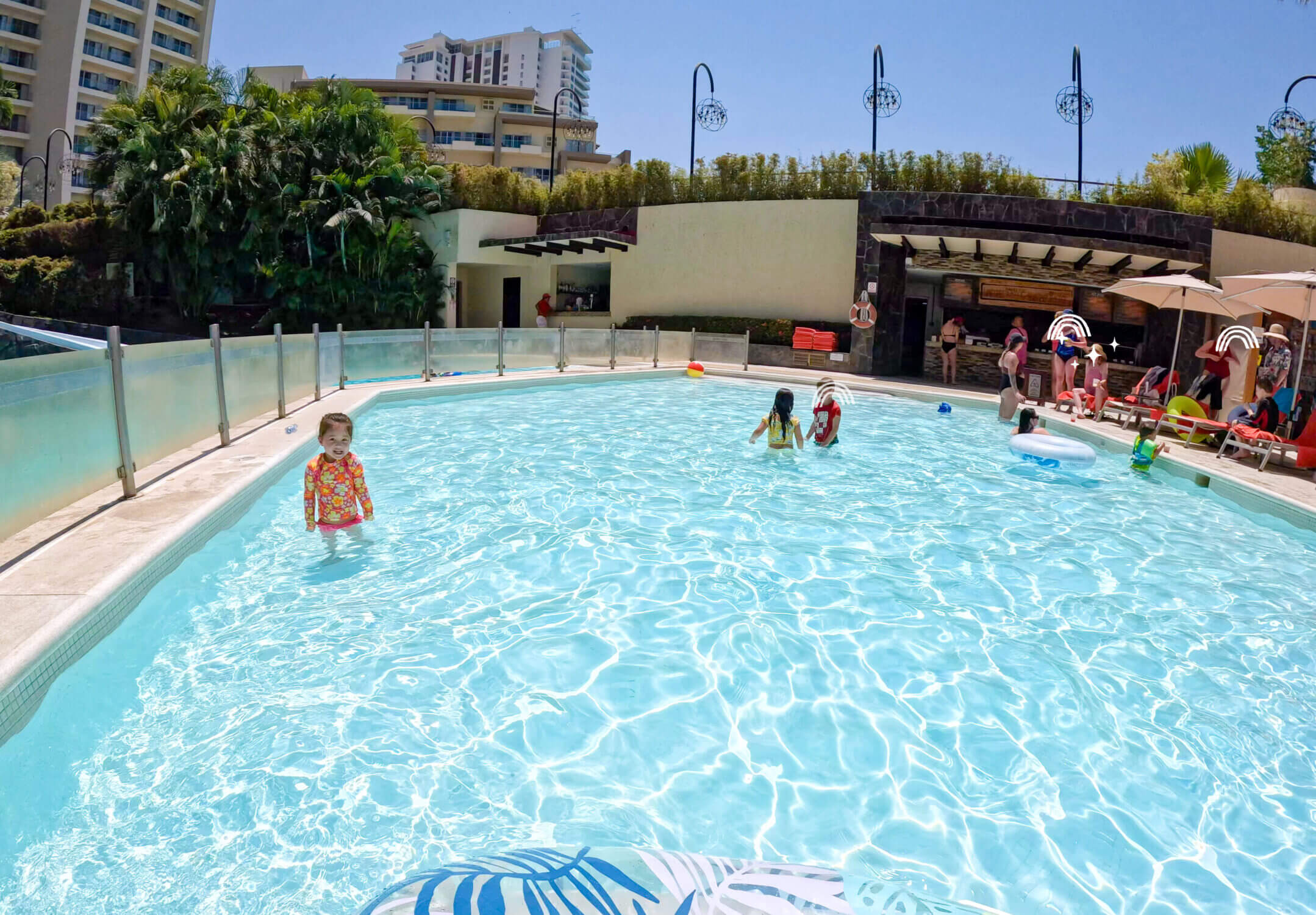Close-up view of the spacious toddler pool at Dreams Vallarta Bay Resort, designed with the youngest guests in mind. Shallow at just 1.5 feet deep, the pool offers a safe and fun place for toddlers to splash and play. Just steps behind the pool is the convenient poolside restaurant, a family favorite for quick bites like pizza and chips with guacamole—perfect for easy lunches without leaving the water fun. With delicious food and thoughtful kid-friendly amenities, this all-inclusive resort makes vacationing with little ones a breeze.