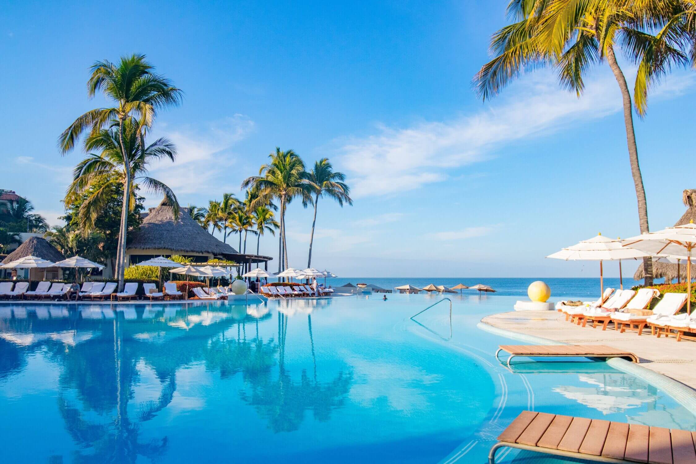 View of the stunning multi-tiered infinity pool at Grand Velas Riviera Nayarit, designed with families in mind. With shallow-entry areas perfect for younger kids, poolside service, and panoramic views of the Pacific Ocean, this luxurious all-inclusive resort creates a relaxing and safe environment for family fun in the sun.