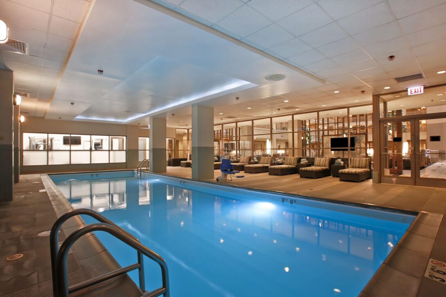 Embassy Suites by Hilton Chicago indoor swimming pool, a family favorite hotel in River North. The pool area features a large heated pool surrounded by lounge chairs and windows that let in natural light — perfect for relaxing after a day exploring Chicago with kids.