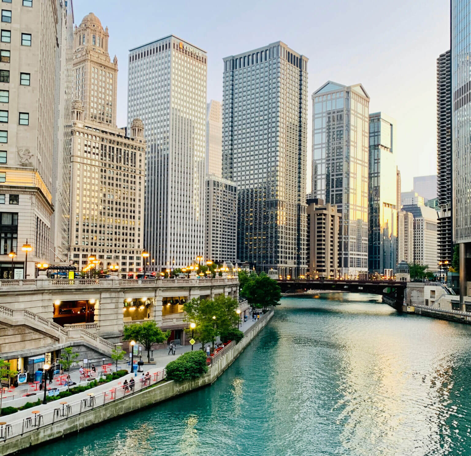 A scenic view of the River North neighborhood in Chicago, featuring the iconic Chicago Riverwalk with towering high-rises and renowned architecture lining the water—showcasing the city’s urban beauty and walkability.