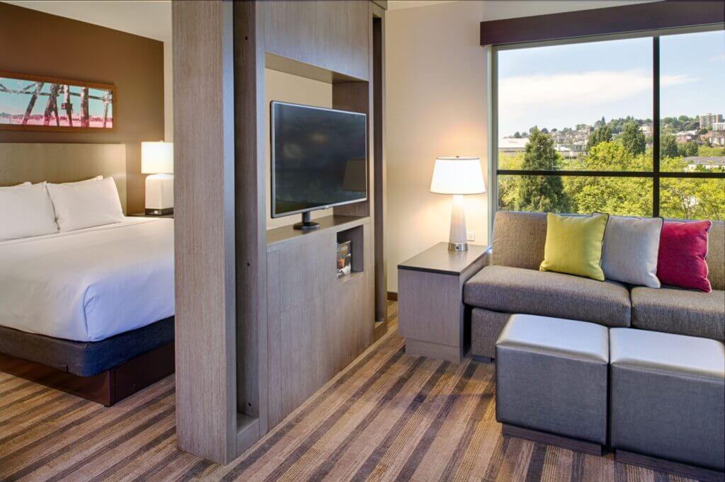 Interior view of a studio suite at Hyatt House in Seattle’s Queen Anne neighborhood, featuring a bedroom and separate living room area—perfect for families looking for extra space and comfort while visiting with kids.