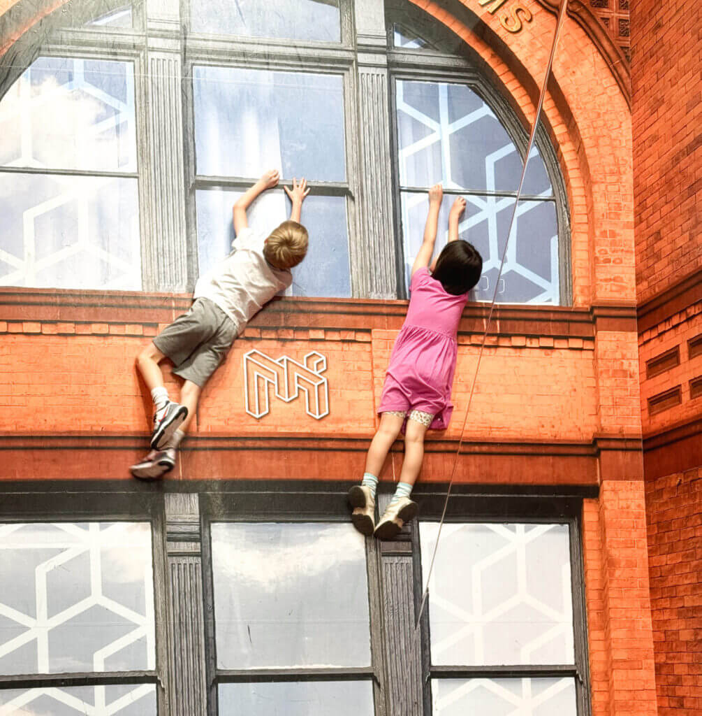 Two kids laughing and playing inside the immersive Museum of Illusions in downtown Seattle, where interactive exhibits and optical illusions make it a top indoor attraction for families and one of the best things to do with kids in Seattle.