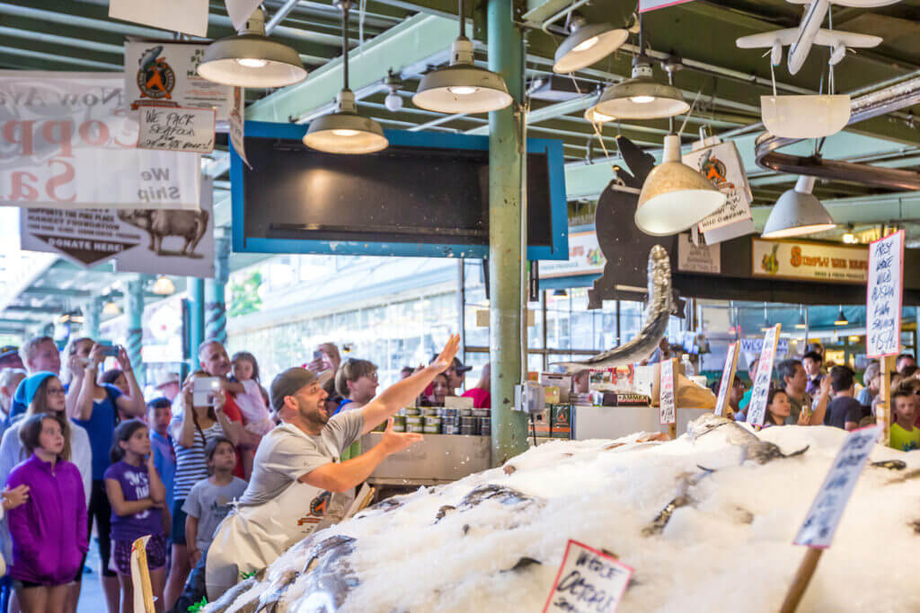 Kids watching in awe as fishmongers at Pike Place Fish Co. toss a large fish through the air at Seattle’s famous Pike Place Market. One of the most exciting and iconic experiences for families visiting Seattle, this lively fish-throwing tradition captures the spirit of the market and always draws a crowd.