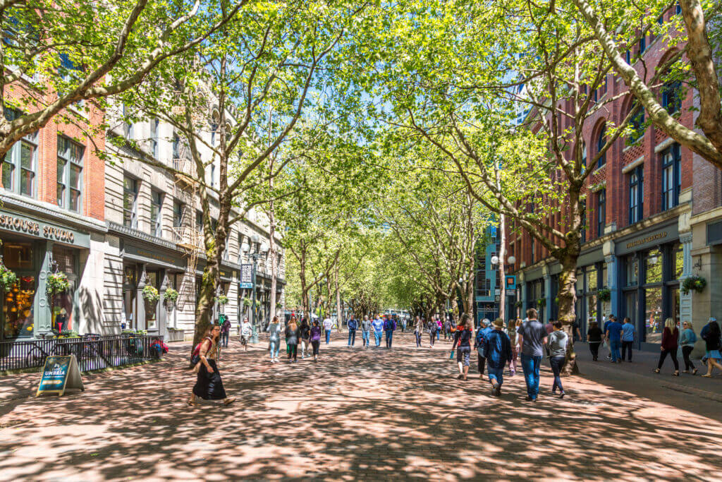 View of Pioneer Square in Seattle, showcasing the historic architecture and tree-lined streets of the city’s oldest neighborhood. This area is home to the famous Seattle Underground Tour and located near the sports stadiums, though visitors with kids should exercise caution at night.